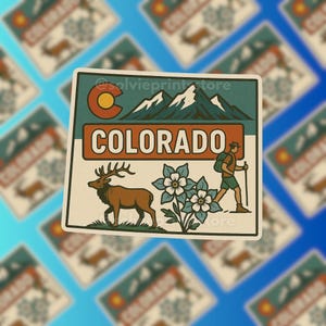 May include: A rectangular sticker featuring a Colorado design. The sticker includes the word "COLORADO" in a bold orange font, a mountain range, a hiker, a deer, and blue and white flowers. The sticker has a cream-colored border and a blue background.