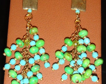 May include: A pair of gold dangle earrings with turquoise and green beads. The earrings have a square-shaped top piece and multiple strands of beads.