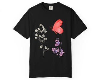 Peut inclure: T-shirt noir avec un papillon rouge et des illustrations florales blanches et violettes. Le papillon a un motif d'ailes détaillé. Les fleurs sont délicates et détaillées. Le t-shirt est de style col rond classique.