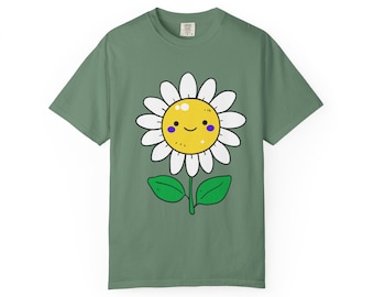 以下が含まれることがあります： 笑顔の漫画のデイジーが描かれたセージグリーンのTシャツ。 デイジーは白い花びら、黄色の中心、紫色のアクセントがあります。 緑の葉と茎があります。 シャツはカジュアルで快適なスタイルです。