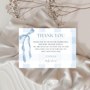 Może przedstawiać: Karta z podziękowaniami na baby shower z niebieskim wzorem w kratkę i akwarelową wstążką. Karta zawiera napis "DZIĘKUJĘ" oraz wiadomość z podziękowaniami i imię "EMMAS".
