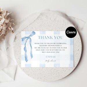 Może przedstawiać: Karta z podziękowaniami z baby shower z niebieskim wzorem w kratkę i akwarelową kokardą. Karta zawiera napis "THANK YOU", spersonalizowaną wiadomość i imię "EMMAS".