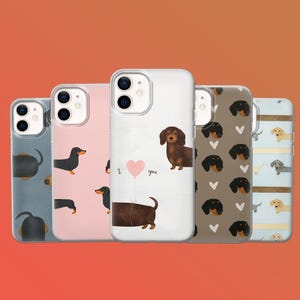 May include: A collection of phone cases with dachshund designs. The cases feature various patterns, including illustrations of the dogs, hearts, and the phrase "I love you." The cases are in shades of blue, pink, brown, and white.