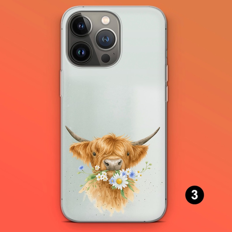May include: A phone case featuring a watercolor illustration of a Highland cow with a bouquet of daisies and blue flowers in its mouth. The case has a light green background and a clear border.