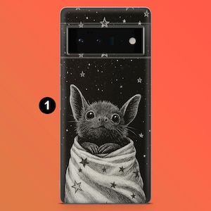 May include: A black phone case featuring a cute bat illustration wrapped in a blanket with star patterns. The background is black with white stars. The phone case has a camera and flash.