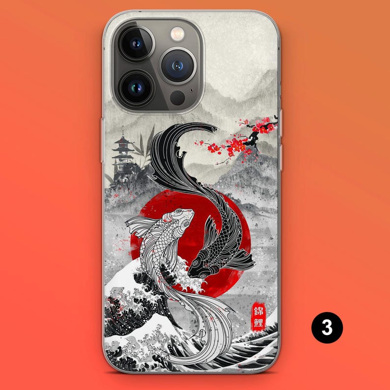May include: A phone case featuring a Japanese-inspired design. The case showcases two koi fish, one black and one white, against a red sun and a backdrop of mountains and cherry blossoms. The design includes a pagoda and a wave.