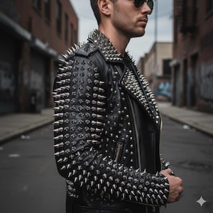 May include: Black leather jacket heavily embellished with silver metal spikes. The jacket features a classic biker style with a notched collar, zipper closure, and multiple spikes on the shoulders, sleeves, and back. The jacket is worn in an urban setting.