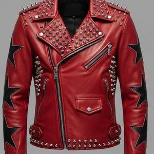 May include: Red leather jacket with a black star design on the sleeves. The jacket features silver studs on the shoulders, collar, and around the waist. It has a zipper closure and a small pocket.