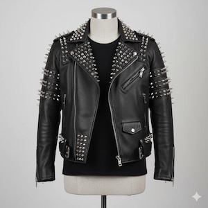 May include: Black leather jacket adorned with silver metal spikes on the shoulders, collar, and sleeves. The jacket features a classic biker design with a zip closure, pockets, and a notched lapel. It is displayed on a mannequin.