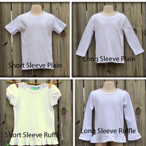 May include: Four white t-shirts on mannequins, displayed on a wooden background. The shirts are shown in two sleeve lengths: short and long, and two styles: plain and ruffle. The text "Short Sleeve Plain", "Long Sleeve Plain", "Short Sleeve Ruffle", and "Long Sleeve Ruffle" is displayed below each shirt.