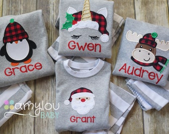 May include: Four gray and white striped pajamas with different embroidered Christmas characters and names. The characters include a penguin, a unicorn, a moose, and Santa Claus. The names are Grace, Gwen, Audrey, and Grant.