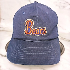 May include: Navy blue baseball cap featuring the word "Bears" embroidered in orange and blue. The cap has a curved peak and a mesh back. A classic sports accessory.