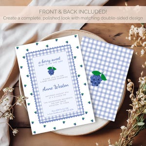 May include: Baby shower invitation with a blueberry theme. The invitation has a white background with a blue gingham pattern and a decorative border. The text reads "a berry sweet BABY IS ON THE WAY". The back of the invitation has a matching design.