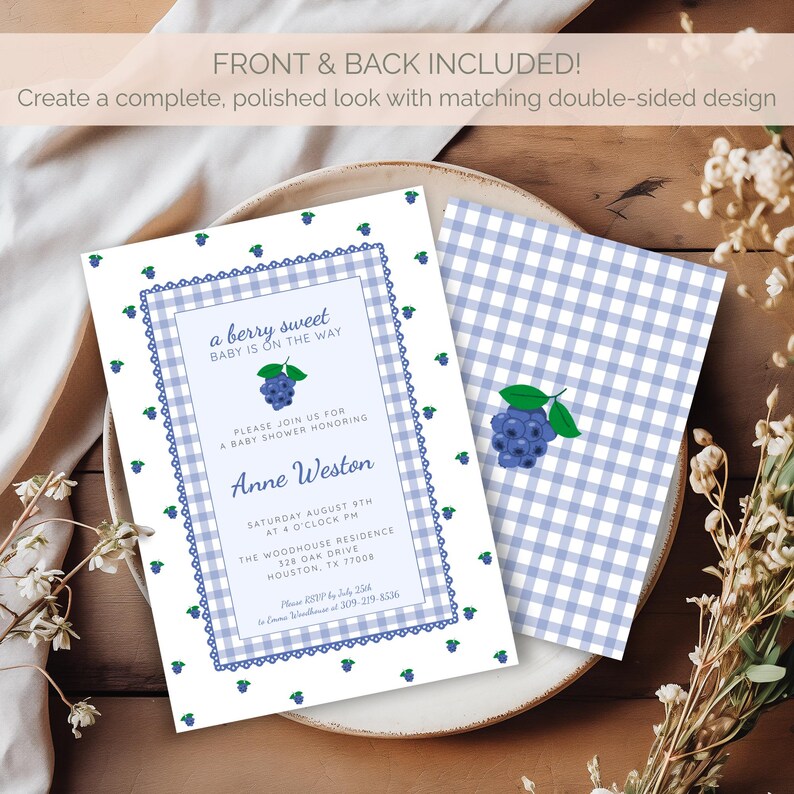 May include: Baby shower invitation with a blueberry theme. The invitation has a white background with a blue gingham pattern and a decorative border. The text reads "a berry sweet BABY IS ON THE WAY". The back of the invitation has a matching design.