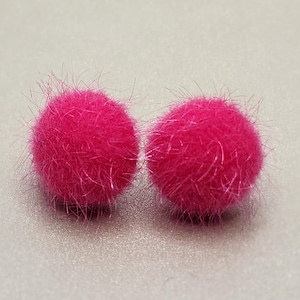 May include: A pair of pink fuzzy pom pom earrings.