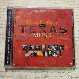 May include: A red CD case with a star on the bottom corner. The case features a collage of musicians and the text "Don't Mess with Texas Music" in black and white.