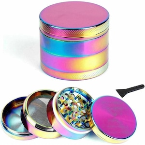 May include: A multi-layered, iridescent grinder with a pink top and a small black scraper. The grinder is disassembled, revealing its internal components, including a mesh screen and a grinding chamber. The color transitions through shades of blue, green, and yellow.