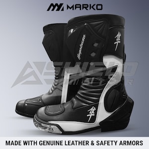 Puede incluir: Un par de botas de motocicleta en blanco y negro con el texto Marko, Hayabusa y caracteres japoneses. Las botas incluyen paneles de protección, secciones texturizadas en la puntera y un diseño alto con refuerzo en el talón y tobillo.