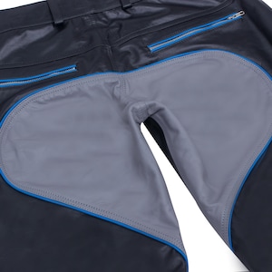 A close-up of the back of black leather pants, showing the gray heart-shaped seat panel with blue piping and belt loops.