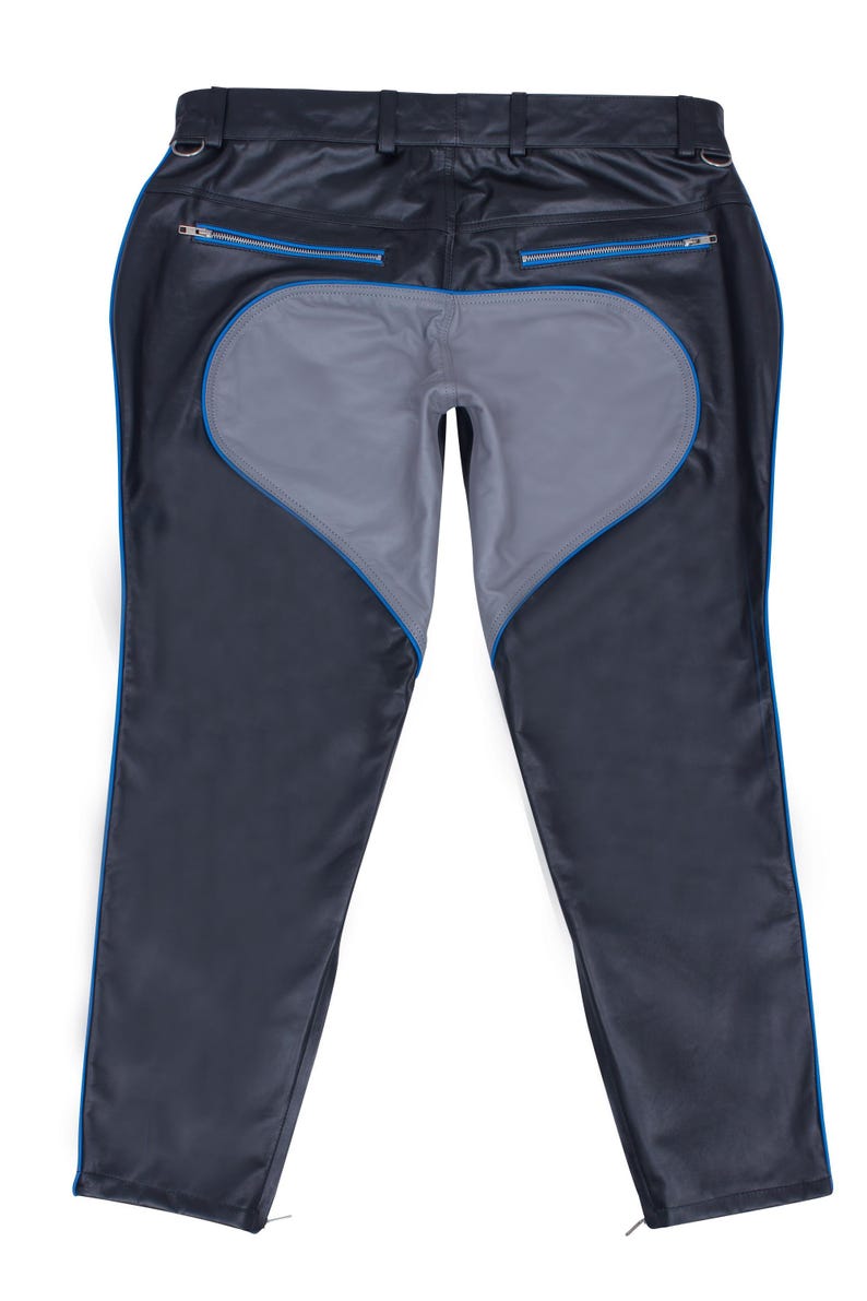 A pair of black leather pants with a gray heart-shaped panel on the seat and blue piping, laid flat, back view.