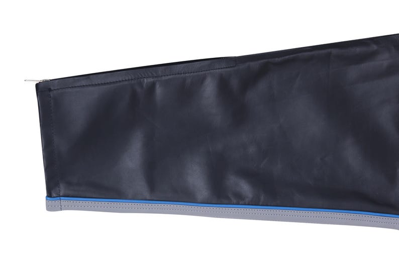 A close-up of the lower leg of black leather pants, showing a gray stripe with blue piping and a zipper at the ankle.