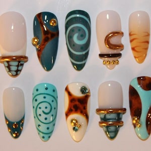 Può includere: Un set di dieci unghie finte con vari design, tra cui spirali color ottanio, motivi tartarugati marroni, accenti metallici dorati e dettagli geometrici blu-verdi. Ogni unghia ha una forma a punta con una finitura lucida e texture varie.