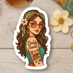 May include: A sticker featuring a cartoon illustration of a woman with sunglasses, a floral headband, and a tattoo that says "Daddy Issues." The woman is wearing a teal top and orange skirt. The sticker has a white border.