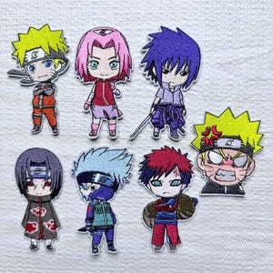 May include: A set of seven embroidered patches featuring chibi-style anime characters. The designs include figures with yellow, pink, purple, black, silver, and red hair, wearing various outfits, including headbands and cloaks with red cloud patterns.