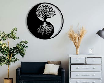 May include: A black metal wall art piece featuring a Yin and Yang symbol with a tree design. The tree's branches and roots are detailed. The circular artwork is mounted on a light grey wall.