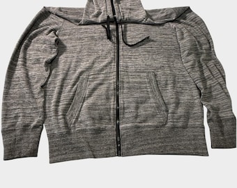 May include: A heathered gray zip-up hoodie featuring a black front zipper, a drawstring hood with black cords, two front pockets, and ribbed cuffs and hem. The interior lining of the hood is black, providing a contrast to the gray exterior fabric.