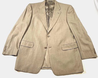 May include: A tan blazer with a two-button closure, notched lapels, and two front pockets. The blazer has a classic design with a tailored fit. The sleeves have buttoned cuffs. The blazer is made of a textured fabric.