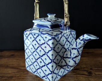 タイ製の青と白の磁器製ティーポット。四角い形状で真鍮製の取っ手が付いています。