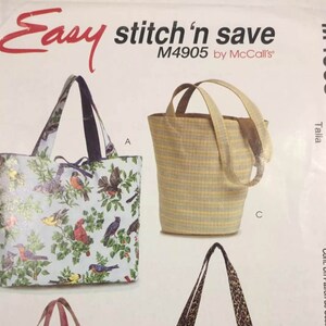 May include: A McCall's M4905 Easy stitch 'n save sewing pattern envelope featuring illustrations of three tote bags. One bag has a light blue fabric with a colorful bird and foliage print, another is a yellow and grey striped bucket bag.