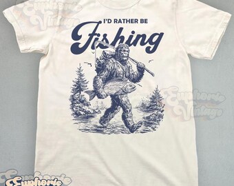 Comfort Colors® I'd Rather Be Fishing Bigfoot T-Shirt, Vintage Cryptidcore Graphic Tee, Gift for Fisherman