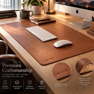 May include: A rectangular brown desk pad with rounded corners and a smooth surface. The bottom right corner features the embossed text "Dad's Desk". The underside of the desk pad is made of a textured natural cork material for grip.