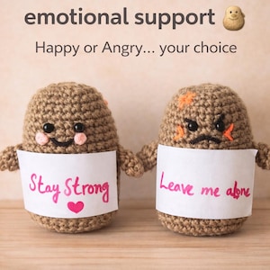 Pode incluir: Duas figuras de batata de crochê. Uma sorri com um letreiro que diz "Stay Strong" e um coração. A outra está com raiva, com um letreiro que diz "Leave me alone". O texto acima diz "Your tiny emotional support."