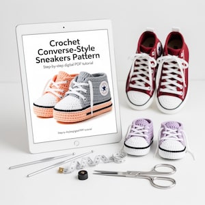 May include: A digital PDF pattern for crochet Converse-style sneakers is displayed on a tablet. The image also shows finished crochet sneakers in red, gray, and lavender, along with crochet hooks, scissors, and a measuring tape.