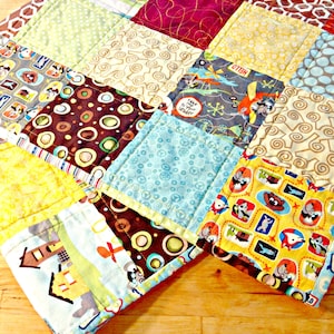 May include: A colorful patchwork quilt with various patterns and colors, including brown, blue, yellow, green, and red. The quilt features a variety of designs, such as polka dots, swirls, and geometric shapes. The quilt is made of different fabrics and textures, creating a unique and visually appealing design.