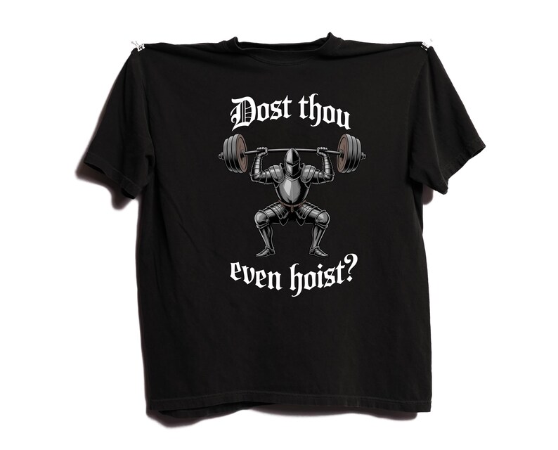May include: Black t-shirt featuring a graphic of a knight lifting weights, with the text "Dost thou even hoist?" in white. The knight is in silver armor, and the barbell has dark gray weights. The shirt is hanging against a white background.