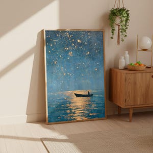 May include: A rectangular framed wall art print featuring a dark blue night sky filled with golden stars above a calm sea. A small silhouette of a person sits in a boat on the water, which reflects a warm golden light from the starry sky above.