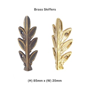 以下が含まれることがあります： 葉の形をした2つのBrass Skiffers金具。1つはダークアンティーク仕上げ、もう1つは光沢のあるゴールド仕上げです。各ピースには取り付け用のネジ穴が2つあり、高さ85mm、幅20mmです。
