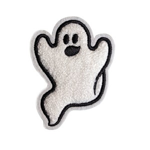 Peut inclure: Fantôme en feutre blanc avec des détails brodés noirs. Le fantôme a un visage souriant avec deux yeux et une bouche.