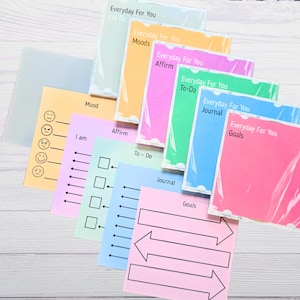 May include: A collection of colorful sticky notes with the text "Everyday For You" and various prompts like "Moods," "Affirm," and "Goals." The notes are in shades of pink, green, blue, and orange, with some packaged in clear plastic.
