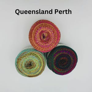 May include: Three skeins of yarn in different colors: a red and orange yarn, a green and yellow yarn, and a dark green and purple yarn.