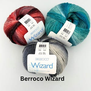 May include: Three skeins of Berroco Wizard yarn in various colors. One is red and black, another is teal and blue, and the third is gray and white. Each skein is labeled with the brand name and product details, including 3.5 oz (100 g) and 262 yds (240 m).