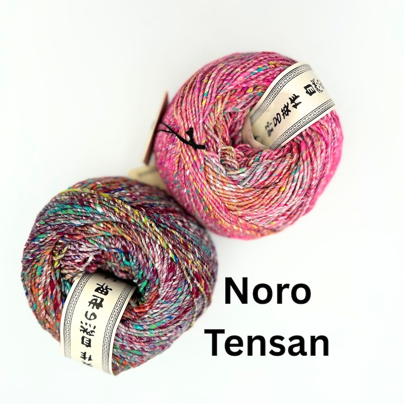 K&ouml;nnte beinhalten: Zwei Kn&auml;uel Noro Tensa Garn in leuchtenden Farben. Das Garn ist eine Mischung aus Rosa, Lila, Gr&uuml;n und Gelb. Jedes Kn&auml;uel hat ein wei&szlig;es Etikett mit japanischem Text. Der Text "Noro Tensa" ist ebenfalls sichtbar.