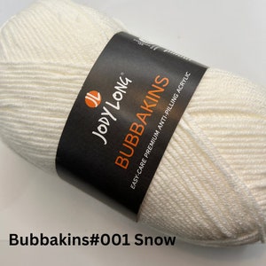 May include: A white skein of yarn labeled "Bubbakins" by Jody Long. The label also states "Easy-Care Premium Anti-Pilling Acrylic". The yarn is labeled "Bubbakins#001 Snow".