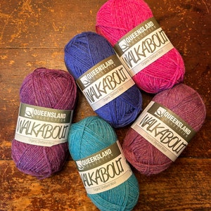 May include: Five balls of yarn in different colors: pink, purple, blue, teal, and a darker purple. Each ball has a label that reads "Queensland Collection Walkabout Organic Shetland Wool."