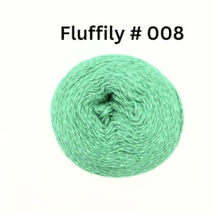 May include: A ball of green yarn with the text "Fluffily # 008" in black. The yarn is a light green colour and appears to be soft and fluffy. The yarn is tightly wound into a ball shape.
