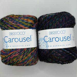 May include: Two skeins of yarn, one in a multi-colored swirl pattern and the other in a dark blue and purple swirl pattern. Both skeins have a white label with the text "Berroco Carousel" and the website address "www.berroco.com".